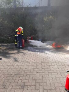 Jugendliche lernen Umgang mit Feuerlöscher